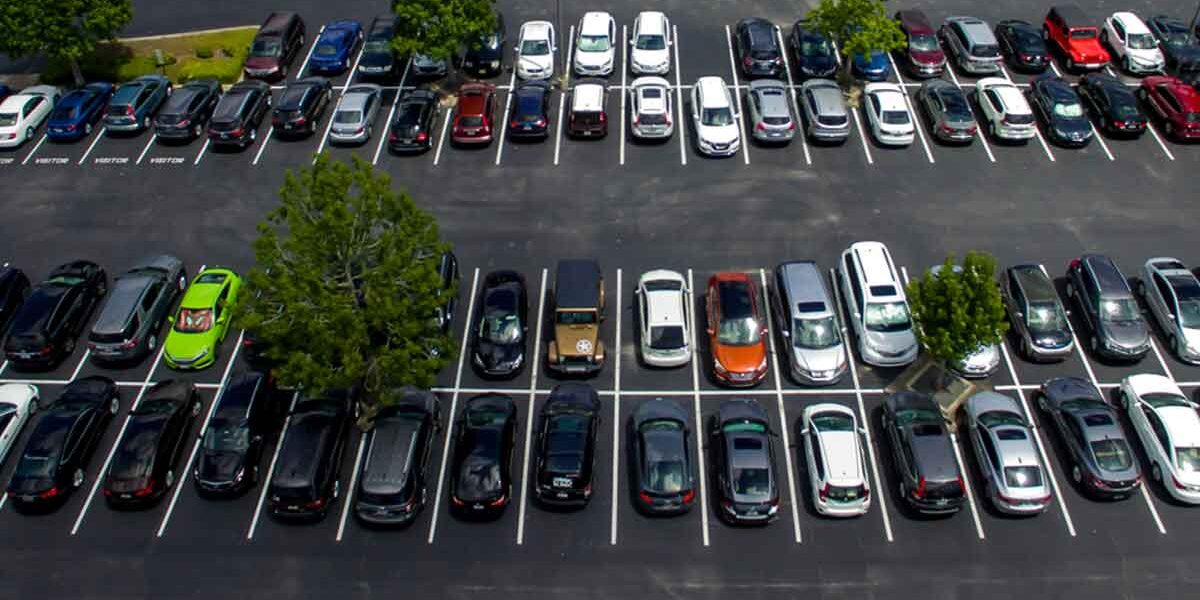 Worn down asphalt parking lot due to a lot of traffic.