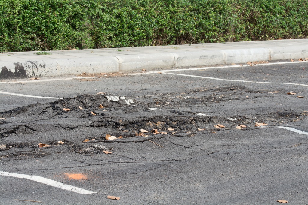 Damaged asphalt parking lot, side low angle.